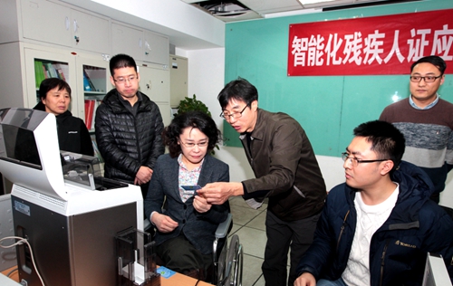 图为海迪主席了解智能化残疾人证制证过程